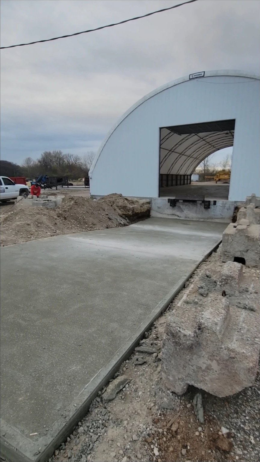 Freshly poured concrete approach leading into a hoop building